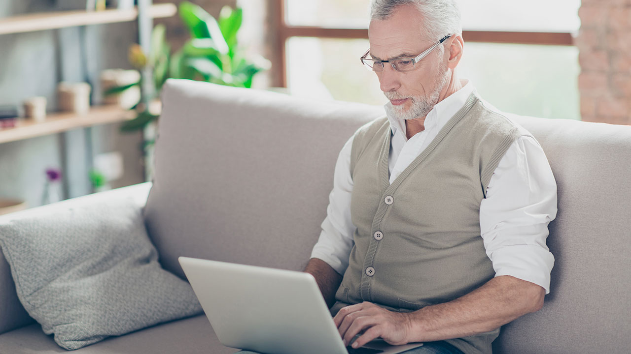 older man checking his account on laptop