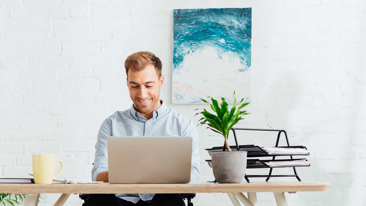 man on laptop sitting at desk