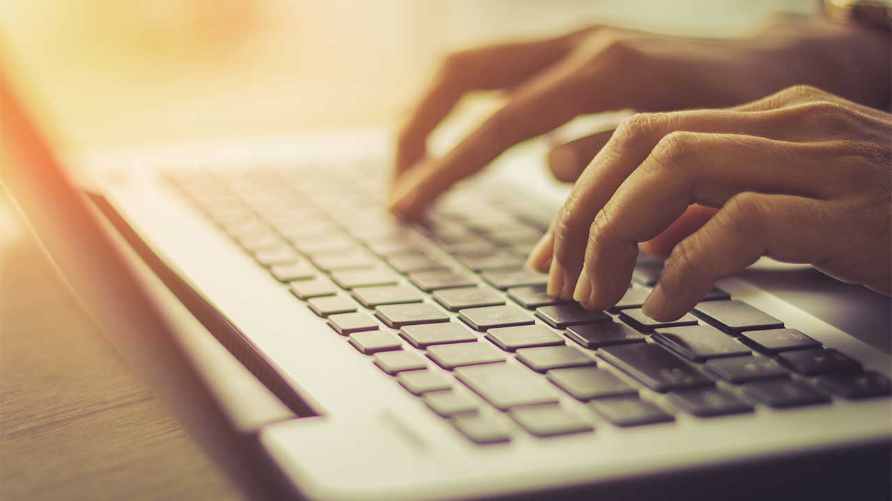 hands typing on a keyboard close up