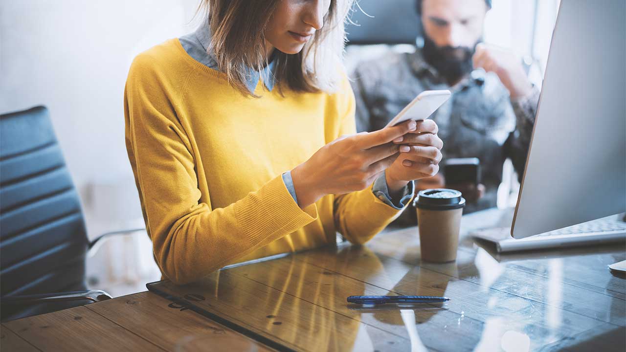 woman using a smartphone at a coffee shop